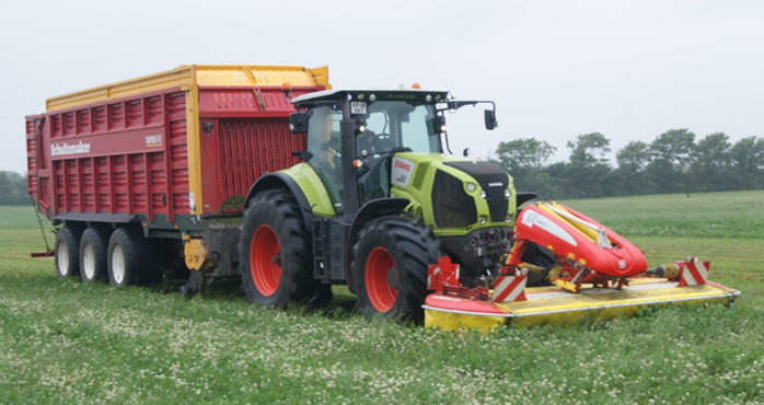 El tractor cosecha el trébol-hierba 